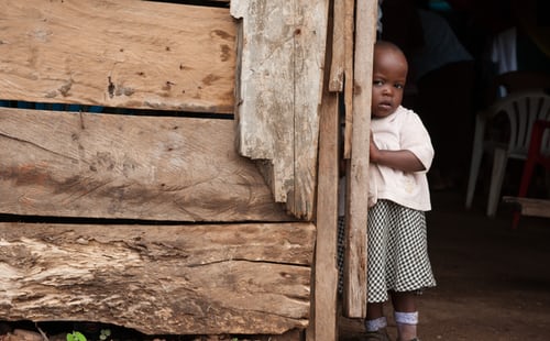 girl-standing-beside-a-wooden-wall-close-up-photography