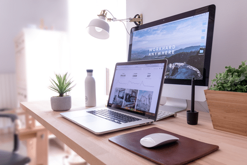 MacBook-Pro-on-table-beside-white-iMac-and-Magic-Mouse