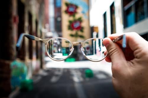 person-holding-eyeglasses